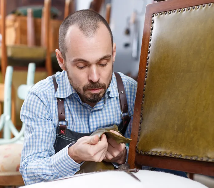 Empleado de la empresa Tapiceros en Madrid restaurando una silla